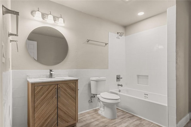 full bathroom featuring shower / bathtub combination, vanity, hardwood / wood-style floors, and tile walls