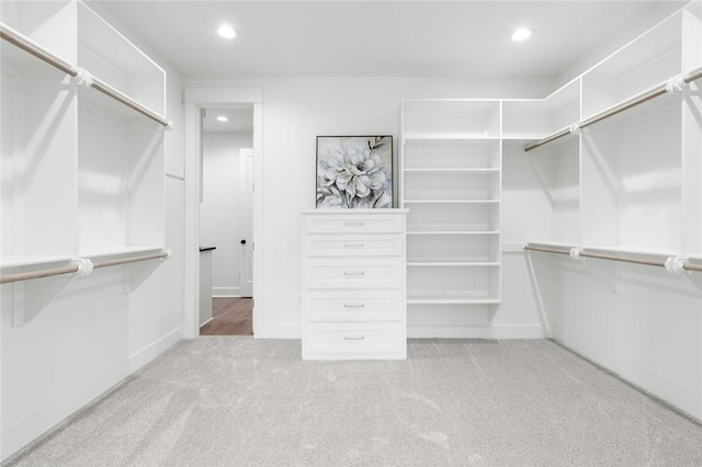 walk in closet with light colored carpet