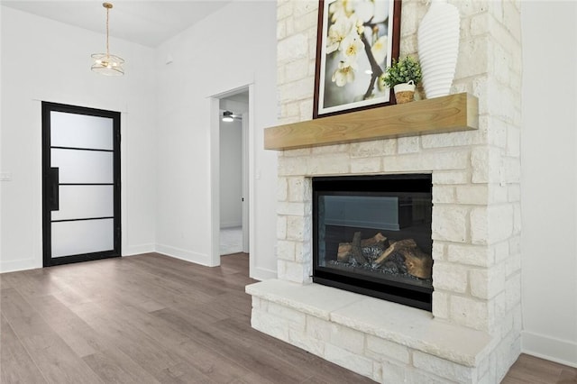 interior space featuring ceiling fan, a fireplace, and wood-type flooring