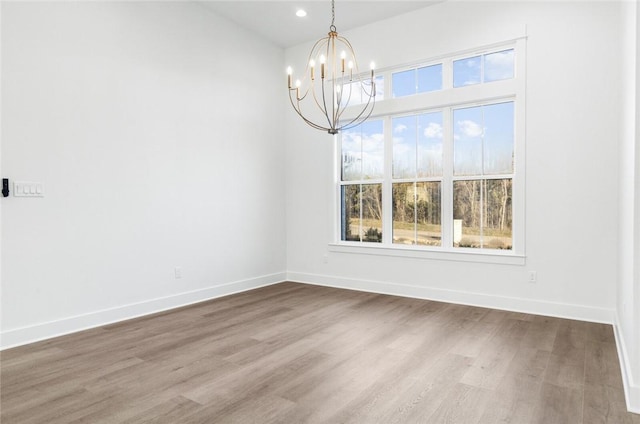 unfurnished dining area with wood-type flooring and a chandelier