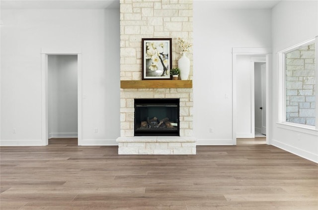 unfurnished living room with a fireplace and light wood-type flooring