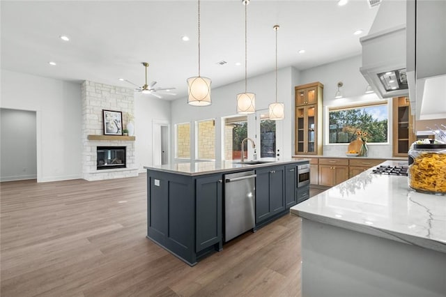 kitchen featuring gray cabinetry, sink, hanging light fixtures, appliances with stainless steel finishes, and light stone counters