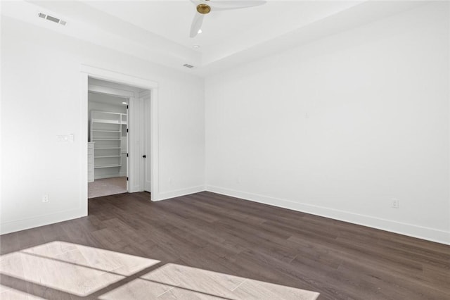 spare room featuring ceiling fan and dark wood-type flooring