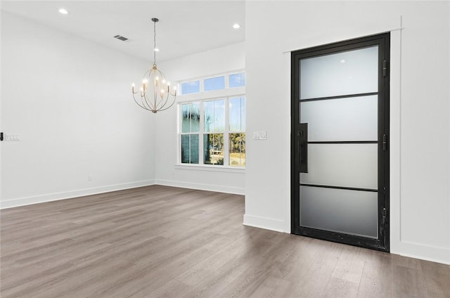 entryway featuring hardwood / wood-style floors and a notable chandelier