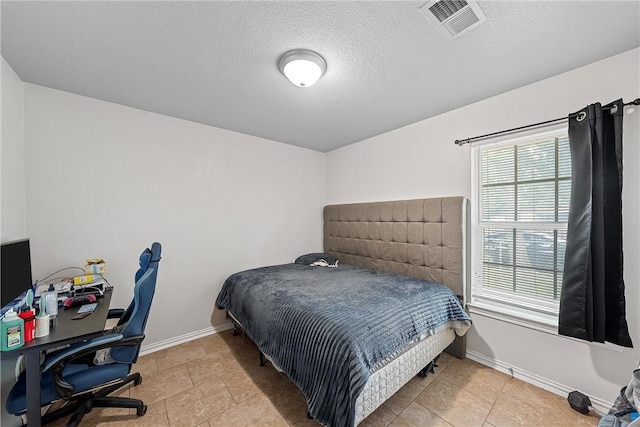 tiled bedroom featuring a textured ceiling