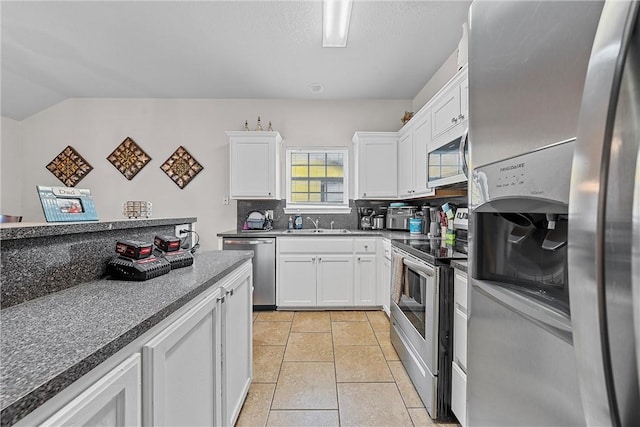 kitchen featuring backsplash, light tile patterned flooring, white cabinets, and stainless steel appliances