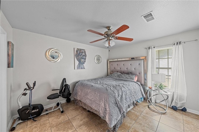 tiled bedroom featuring a textured ceiling and ceiling fan