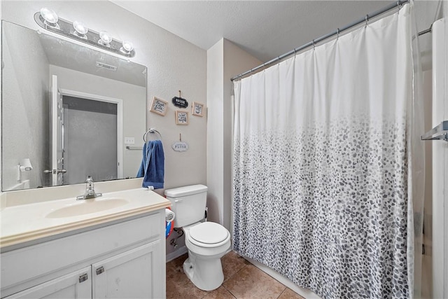 bathroom featuring tile patterned floors, vanity, toilet, and a textured ceiling