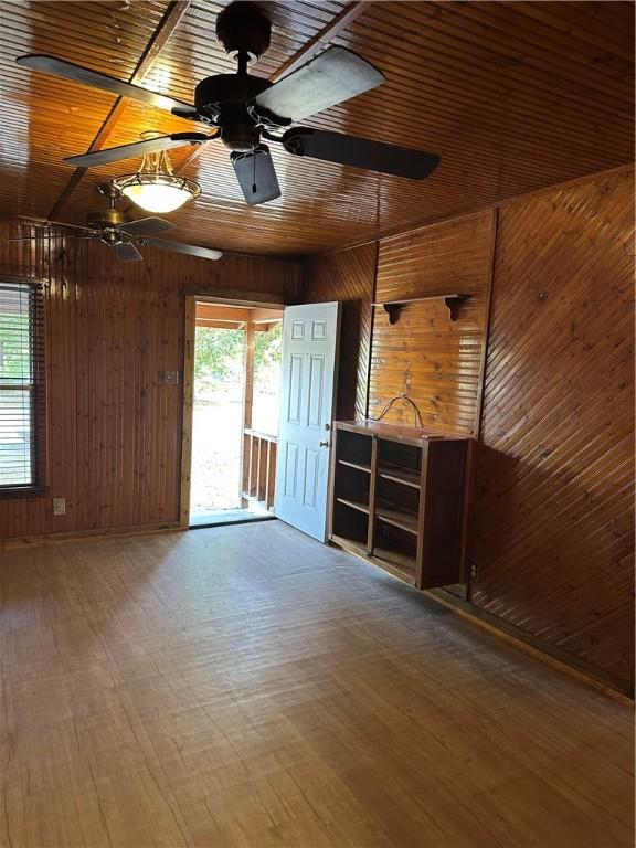 empty room with wood walls and wood-type flooring