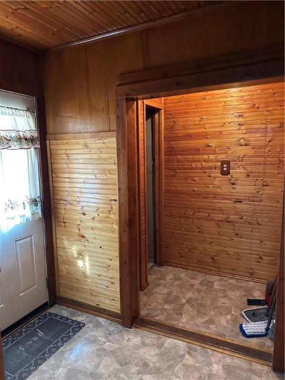 doorway featuring wood walls and wood ceiling