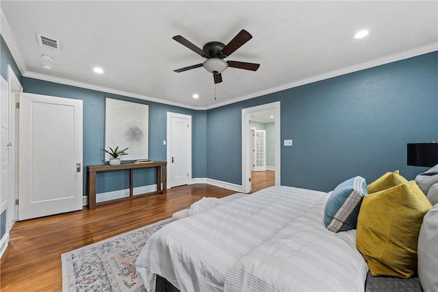 bedroom featuring hardwood / wood-style flooring, ceiling fan, and crown molding