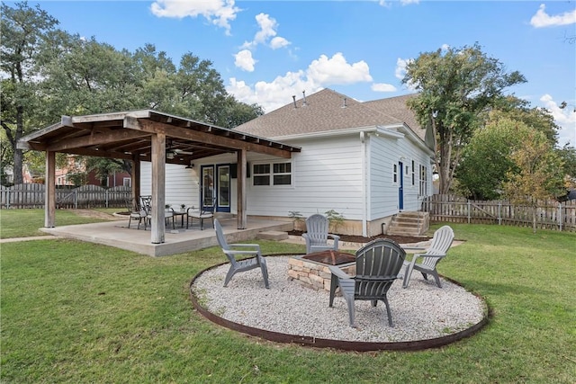 rear view of property featuring a yard, an outdoor fire pit, and a patio area