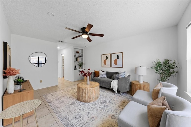 living area featuring visible vents, a healthy amount of sunlight, light tile patterned floors, a textured ceiling, and a ceiling fan