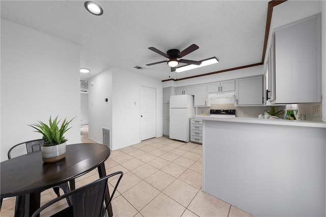 kitchen featuring ceiling fan, under cabinet range hood, light countertops, freestanding refrigerator, and light tile patterned flooring