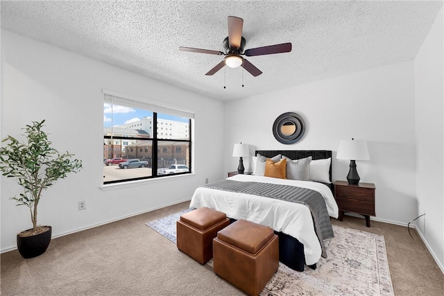 carpeted bedroom featuring a ceiling fan, baseboards, and a textured ceiling