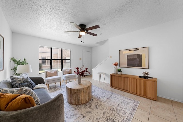 living room featuring a textured ceiling, a ceiling fan, and tile patterned flooring