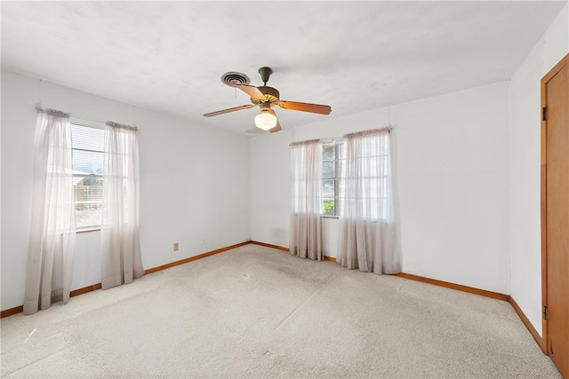 carpeted empty room with baseboards and a ceiling fan