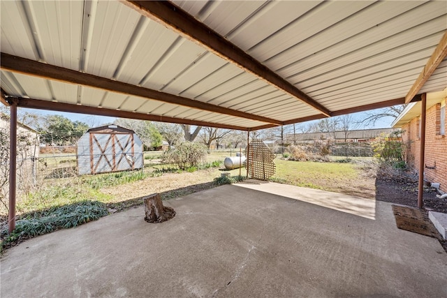 view of patio / terrace featuring a storage shed, an outbuilding, and fence