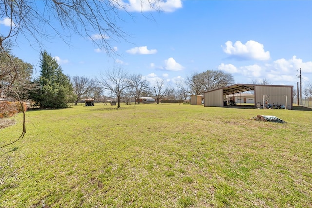 view of yard with a detached carport, an outbuilding, and a pole building