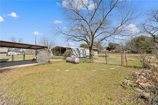 view of yard featuring a carport, fence, and a gate