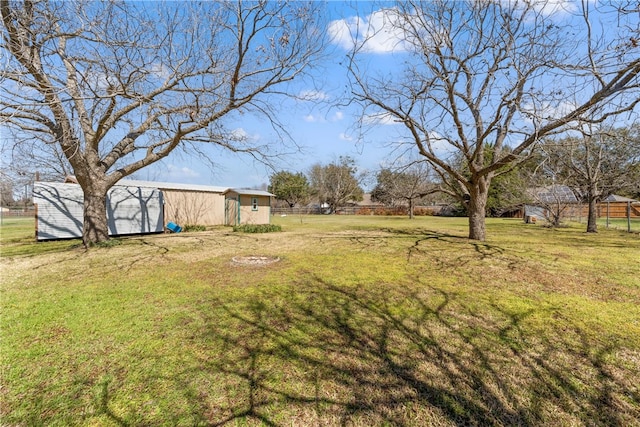 view of yard featuring an outbuilding, an outdoor structure, and fence