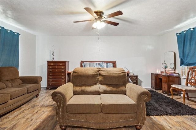 living room featuring ceiling fan, a textured ceiling, and hardwood / wood-style flooring