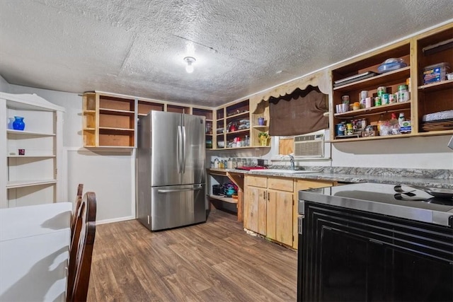 kitchen with sink, stainless steel fridge, a textured ceiling, and wood-type flooring