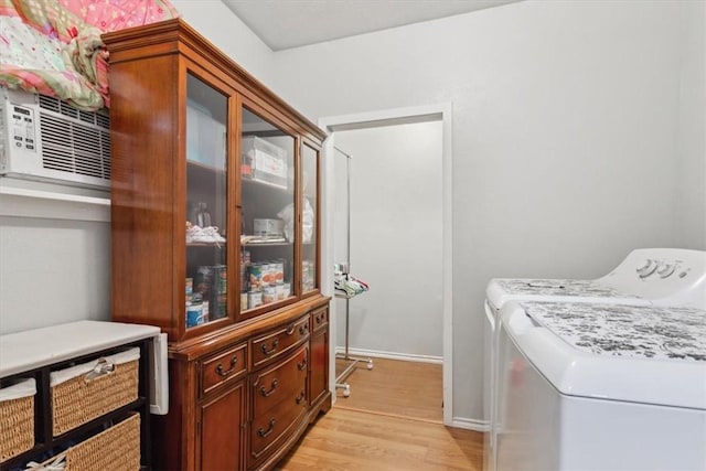 laundry room with separate washer and dryer and light hardwood / wood-style flooring