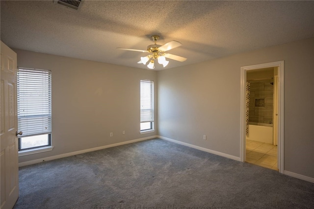 carpeted spare room featuring ceiling fan, a healthy amount of sunlight, and a textured ceiling