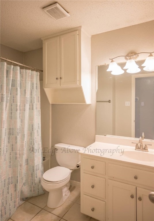 bathroom featuring a shower with shower curtain, vanity, a textured ceiling, and tile patterned flooring