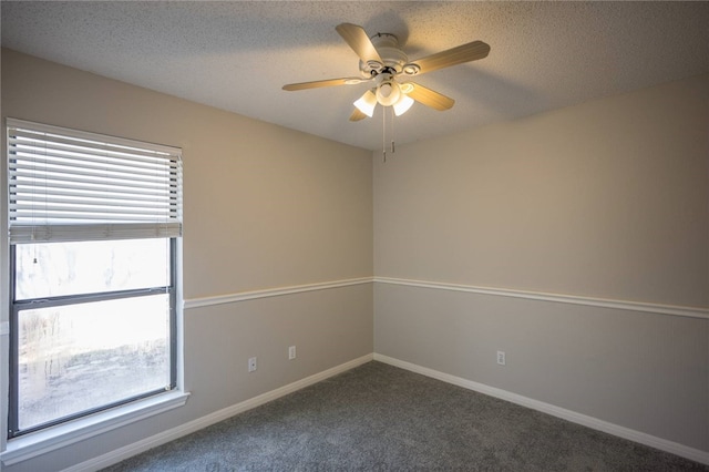 carpeted spare room with ceiling fan and a textured ceiling