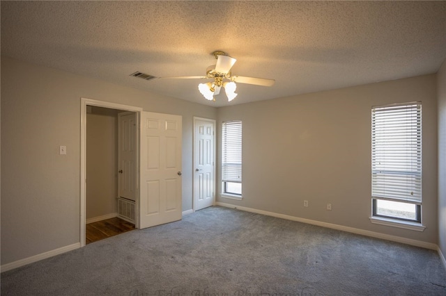 carpeted spare room featuring a textured ceiling and ceiling fan