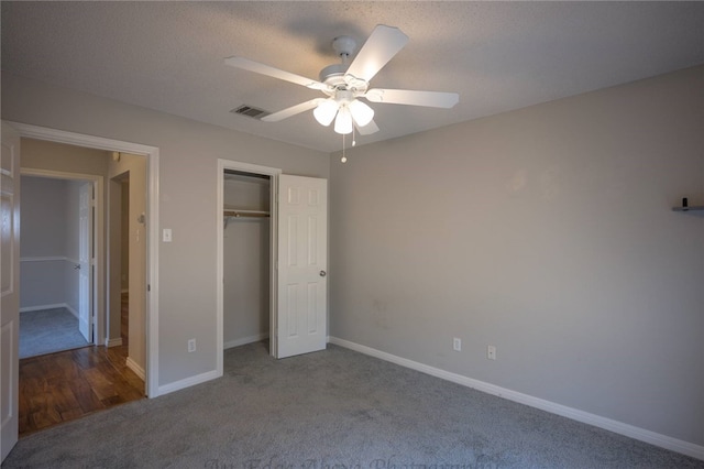 unfurnished bedroom featuring ceiling fan, a textured ceiling, a closet, and carpet flooring