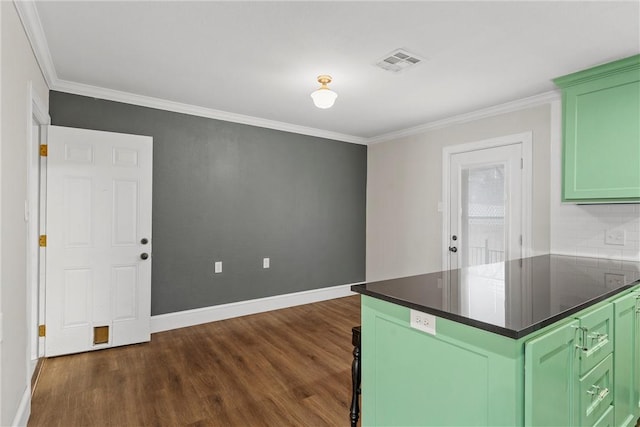 kitchen featuring dark wood-style floors, crown molding, dark countertops, visible vents, and green cabinets