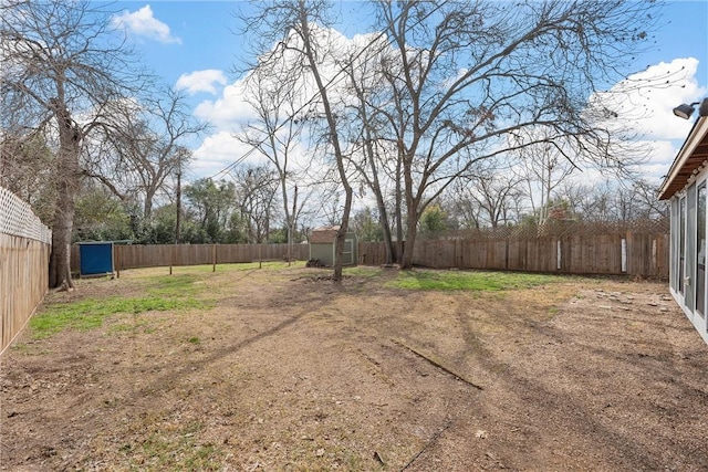 view of yard featuring an outbuilding, a storage unit, and a fenced backyard