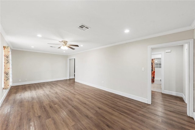 empty room featuring ornamental molding, dark wood-type flooring, visible vents, and baseboards