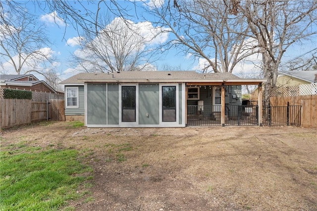 rear view of property featuring a fenced backyard