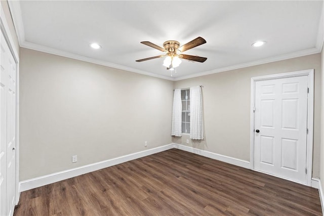 unfurnished room featuring baseboards, dark wood finished floors, and crown molding