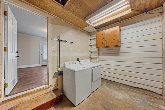 laundry area featuring cabinet space, crown molding, and washing machine and clothes dryer