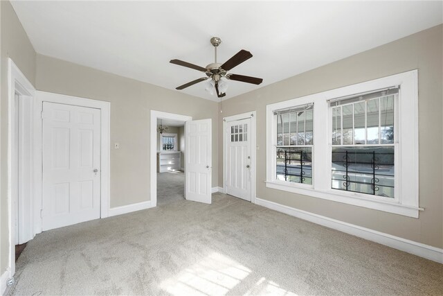 unfurnished room with ceiling fan and carpet