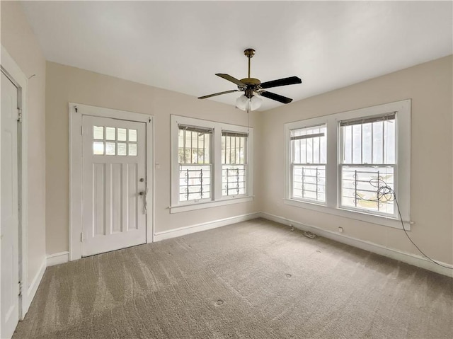 carpeted entrance foyer with ceiling fan