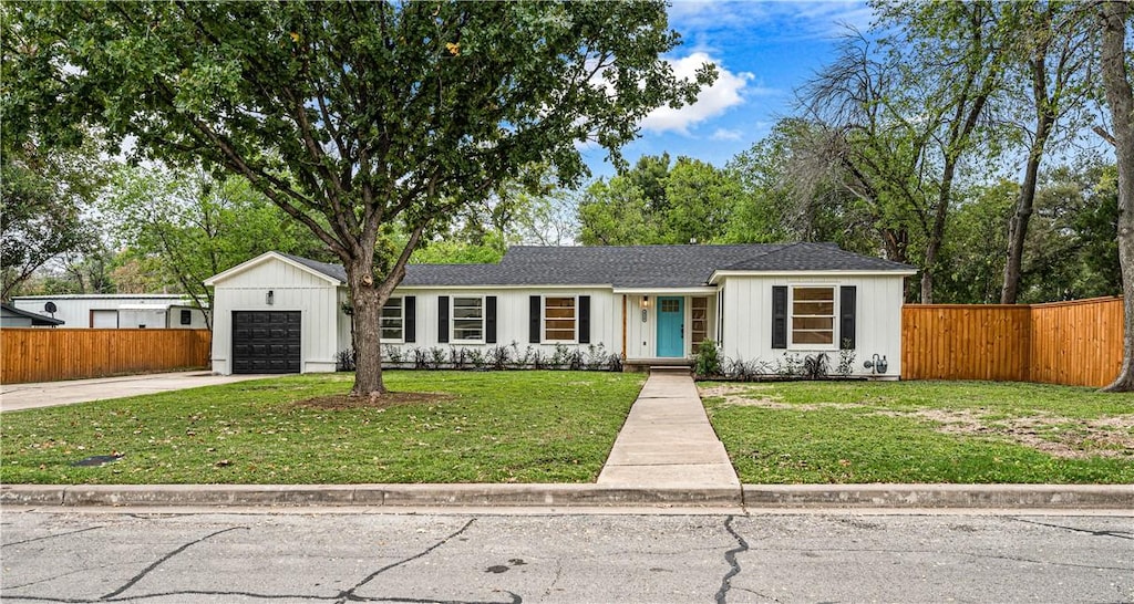 single story home with a garage and a front lawn