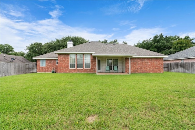 back of property with a lawn and a patio