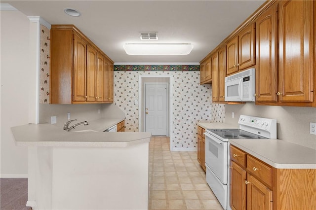 kitchen with kitchen peninsula, crown molding, sink, and white appliances