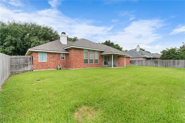 rear view of property with a lawn