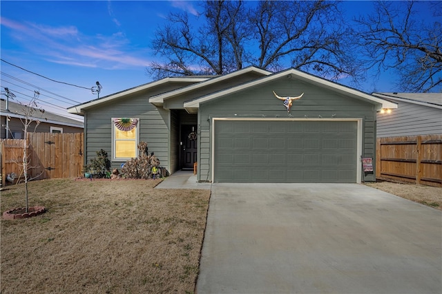 view of front of home featuring driveway, a garage, fence, and a front yard