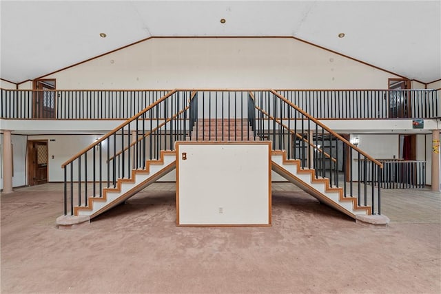 stairs featuring high vaulted ceiling