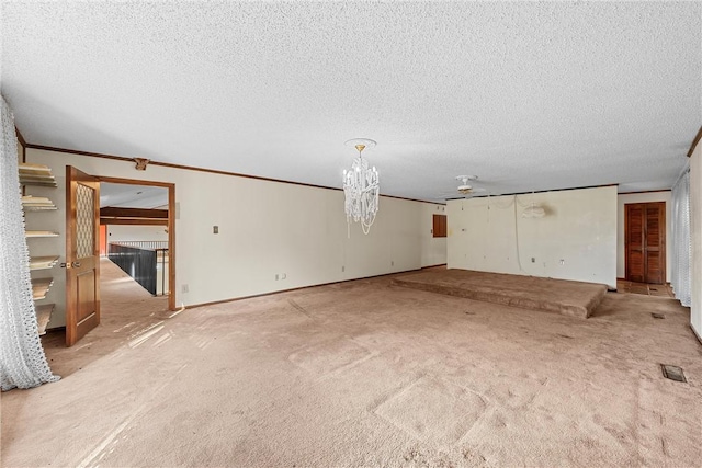 unfurnished living room featuring ceiling fan, crown molding, a textured ceiling, and light carpet