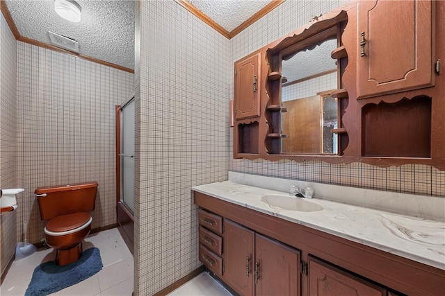 bathroom with tile patterned flooring, crown molding, a textured ceiling, and tile walls