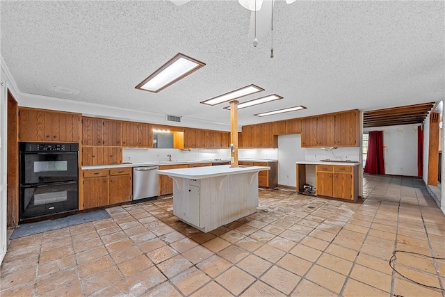 kitchen with stainless steel dishwasher, black double oven, a textured ceiling, a breakfast bar, and a kitchen island